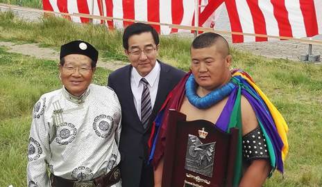 我国驻新潟总领馆总领事孙大纲(中)、新潟内蒙古亲善交流协会副会长深滝信夫(左)为获得一等奖的我区运动员青照日格图颁奖