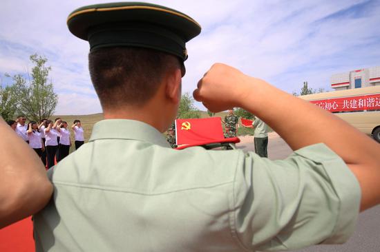 图为边检站党员官兵与学校党员面对党旗庄严宣誓
