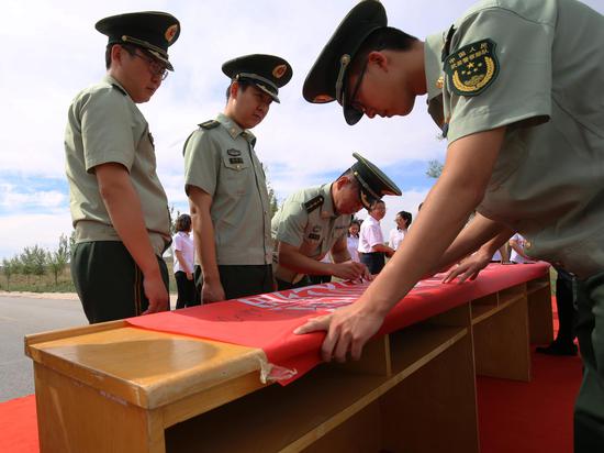 图为双方党员在主题条幅上签字