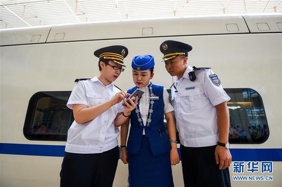 在呼和浩特东站,乘务组人员查看列车运行时间。