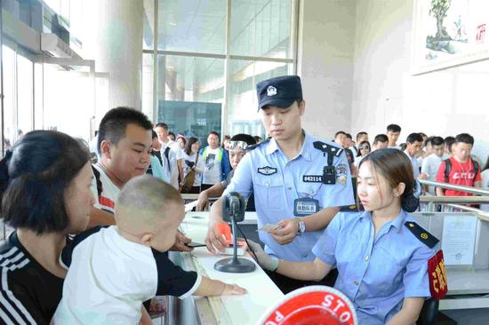 包头铁路公安处民警在包头站候车室检票口核对票证,确保票证人一致,全面加强车站管控力度