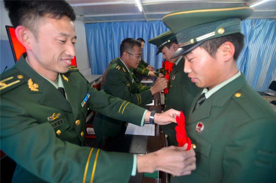 图为该站领导为退役士兵佩戴大红花