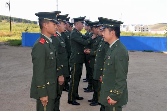 图为该站官兵为退役士兵拆卸警用标识