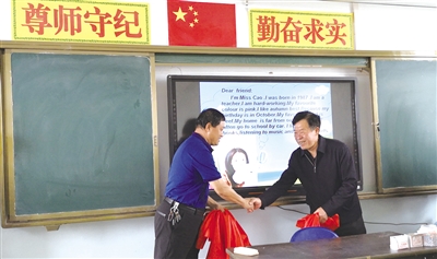 爱心人士(右)为智能教学设备揭牌 摄影/本报记者 郝儒冰