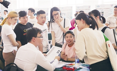 5月15日上午,大学生围着招聘展台进行咨询。