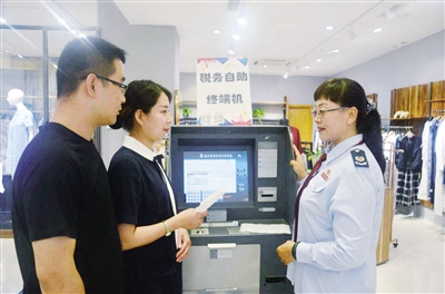 近日,涉税辅导员正在辅导回民区民族商场商户操作代开发票自助终端机。