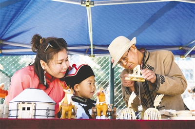 5月29日,在呼和浩特市蒙古族幼儿园北校区,非遗传承人正在介绍非遗作品。