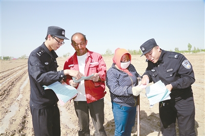 5月13日,民警向两位村民做“扫黑除恶”动员宣传工作。摄影/本报记者 白忠义