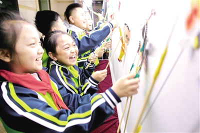 5月21日,小学生在呼和浩特市玉泉区大漠文化创意园内体验皮影戏表演技艺。王磊 摄