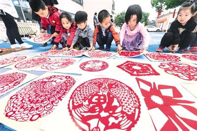 5月22日,孩子们在整理参加义卖的剪纸作品。
