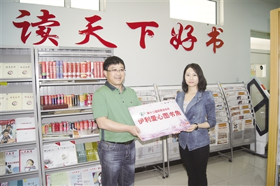 伊利工作人员向学校赠送牌匾