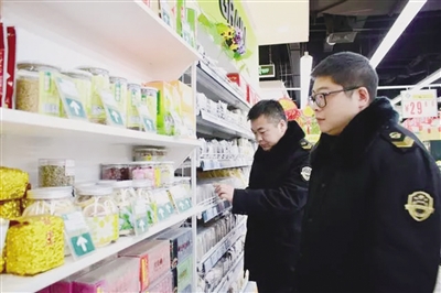食药部门工作人员对超市商品进行检查