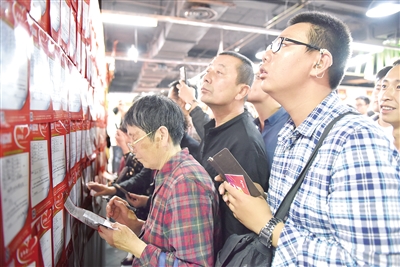 5月20日,相亲墙上贴满单身青年的个人信息,吸引众多市民前来围观。本报记者 王鹏 摄