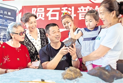 7月20日,内蒙古陨石学会会员在为居民讲解陨石知识。摄影/本报记者 牛天甲