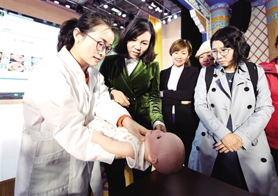 儿科大夫正在给学生家长教授小儿气管支气管异物急救知识。