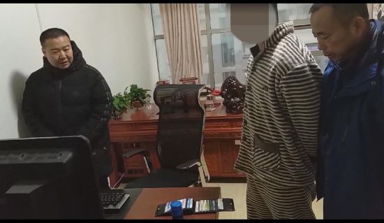 图为民警对嫌疑人涉案电脑进行检查。