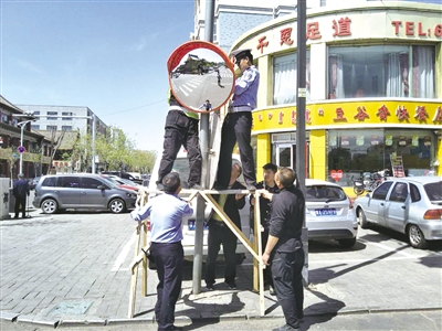 安装道路转弯镜。摄影/本报记者 马丽侠