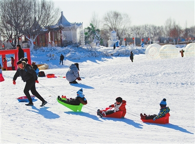 游客在呼和浩特市南湖湿地公园冰雪世界享受冰雪乐趣。