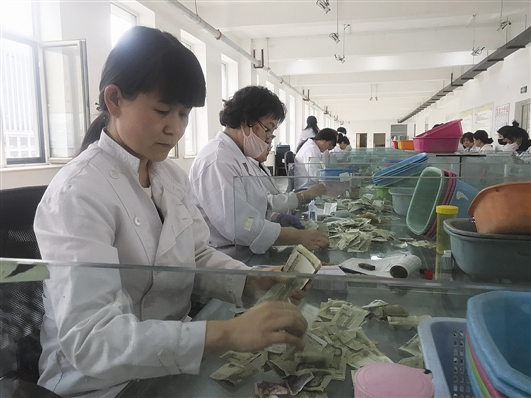 正在清点钱币的张慧萍