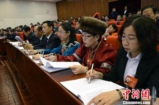 图为与会代表听取政府工作报告。 乌娅娜 摄