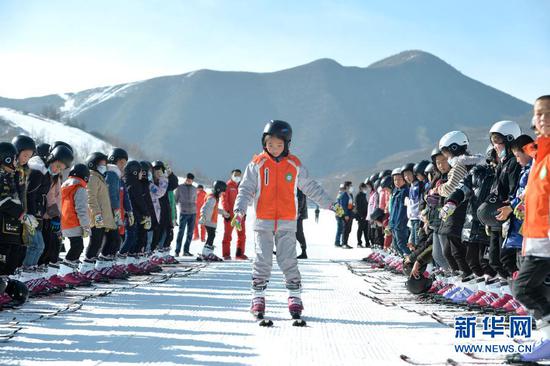 12月27日,在娅豪国际滑雪场内,滑雪爱好者在进行热身活动。