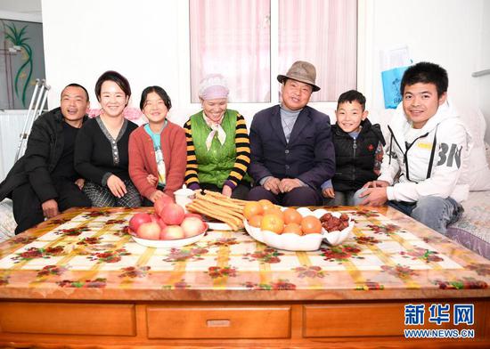2月11日,张俊明(右三)一家人在滨河家园移民村的家里合影。