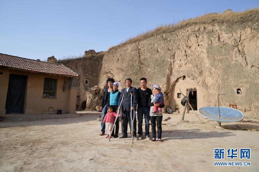 张俊明(中)一家人在固原市彭阳县红白阳镇自家的院子里合影(2013年6月15日摄)。