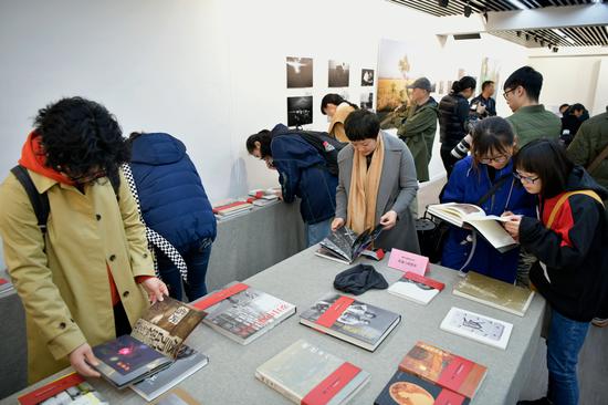 与会者翻阅历届中国摄影图书榜入榜图书。周星宜 摄