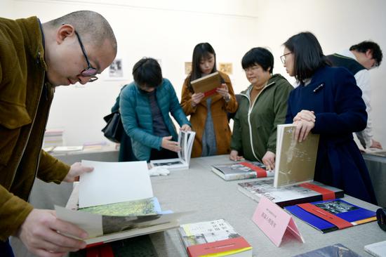 与会者翻阅历届中国摄影图书榜入榜图书。周星宜 摄