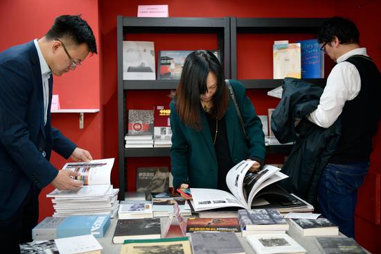与会者翻阅《中国摄影》编辑部推荐阅读书目及《中国摄影》2019年3期“图书榜”专题。周星宜 摄