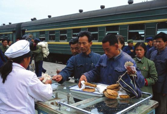 　　火车停在开往西北方向铁路线的一个车站，在中途停靠站台，旅客们下车伸展四肢，向站台上的售货车购买些饮料和食品