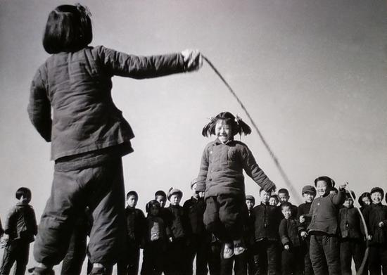 （1956年12月，河北省高阳县邢果庄村的小学生们在空地上跳绳-新华社稿）