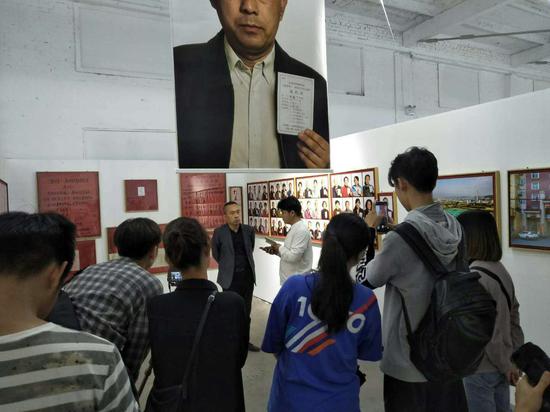 展览现场，摄影师张巍接受记者采访。