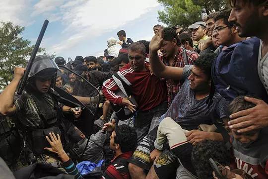 2015年8月22日，马其顿警察举起盾牌阻止难民进入。摄影师：Alexandros Avramidis