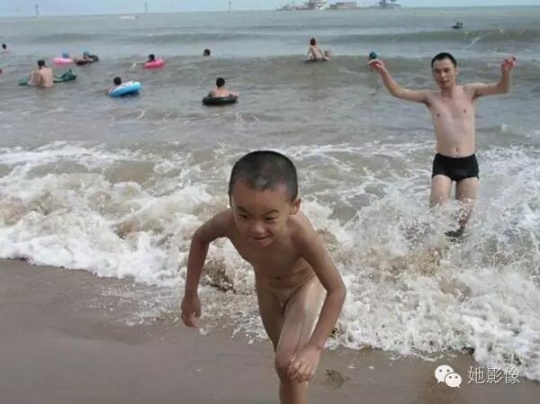 这张照片是康康6岁时在北戴河跟爸爸嬉水的情景，浪花和爸爸追过来，康康兴奋地往岸边跑。  摄影/邹文
