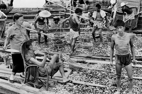 1989年南充城区。夏日里，船老板一边享受着打蒲扇的老妇送来的凉风，一边训斥着给自己脸色看的农民工。