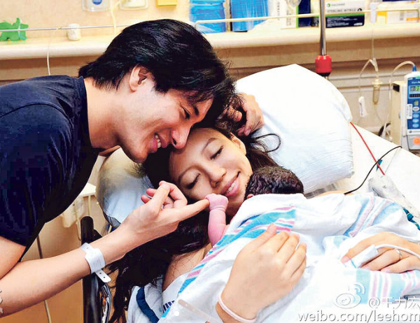 王力宏贴着太太李靓蕾的额头,牵着刚出世女儿王嘉娜的小手,幸福满泻。(微博图片)