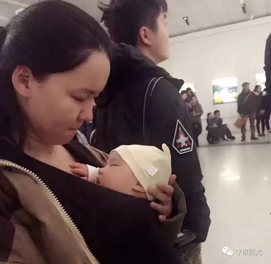 最小的来宾——两个月的宝宝，在作为摄影记者的妈妈的怀里酣睡