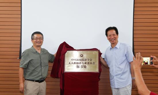 中国新闻摄影学会会长徐祖根(右)与光明网总裁杨谷为无人机专委会秘书处揭牌。(李运恒摄)