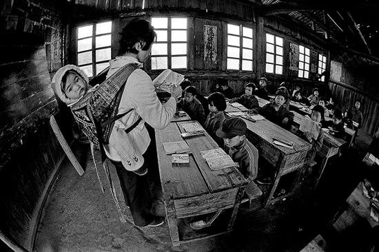 1987年4月,广西壮族自治区融水县安太乡寨怀村小学,戴红英老师把不满五个月的小女儿背着上课。