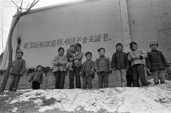 1992年2月,甘肃省康乐县高集乡,村舍上到处可见这样的标语“莫为近利误前程,快送子女去读书”。