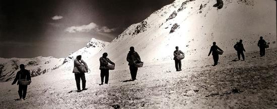 （1959年6月，甘肃融冰化雪大队在冰川上铺撒黑色物质，加速冰层融化-新华社稿 张培元 摄）