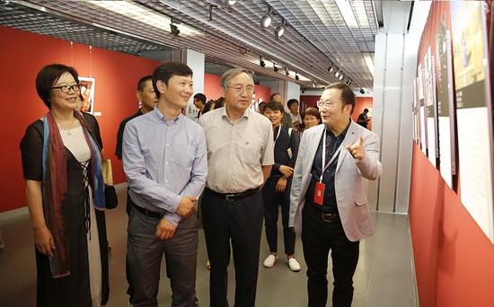 李舸(左二)、郑更生(右二)、高琴(左一)在高大鲲的陪同下参观手机单元入展作品。 张双双 摄