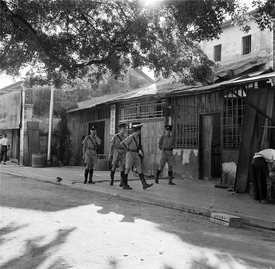 中英街上香港警察在英属街道巡逻(50年代)，郑中健摄。