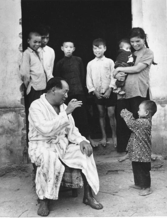 毛泽东畅游湘江后在农家门口与小孩逗趣。（1958年） 侯波 摄