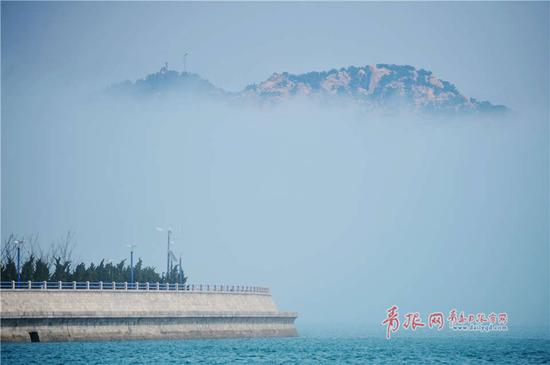 受春季温差影响,崂山区出现平流雾,远处崂山在海上时隐时现美如仙境。