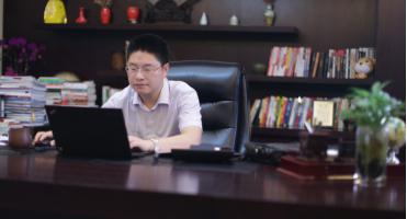 图为:胡玉建坐在办公室里工作