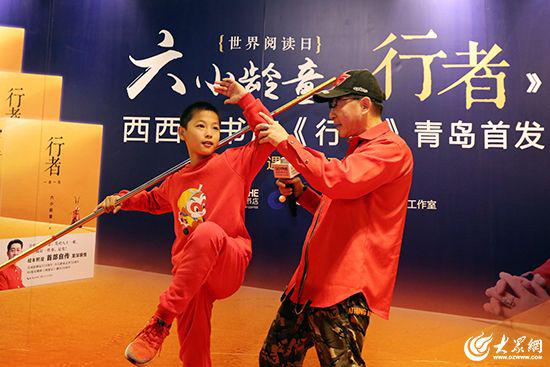 六小龄童现场与小粉丝切磋表演金箍棒。 大众网记者毕天宇摄