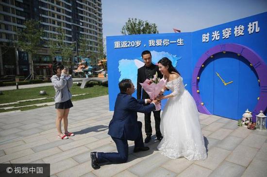 小于的母亲从“时光机”里出来,老于手捧鲜花向王女士“求婚”。