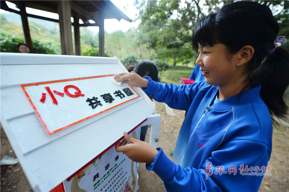 2017年10月9日，来自青岛市第26中学的徐彤羽对“小Q共享书屋”进行擦拭清理。